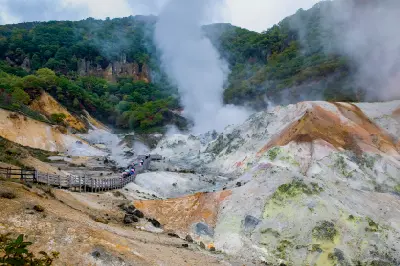 Boardwalk leading into the steaming geothermal basin of Jigokudani Hell Valley in Noboribetsu, Hokkaido, Japan.