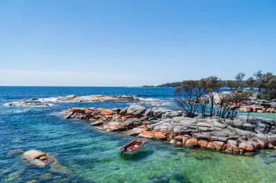 Orange granite rocks and clear turquoise water at Binalong Bay in the Bay of Fires, Tasmania, Australia.