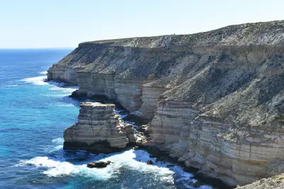 Island Rock rises from the Indian Ocean beneath the layered coastal cliffs of Kalbarri.