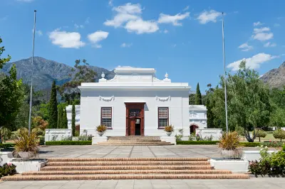 Huguenot Memorial Museum building in Franschhoek surrounded by formal gardens and Cape Fold Mountains in South Africa.