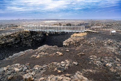 Footbridge crossing the tectonic crack of the Álfagjá rift marking the boundary between the North American and Eurasian plates on the Reykjanes Peninsula, Iceland.
