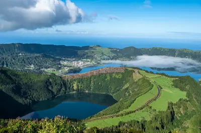 Panoramic view from Miradouro da Boca do Inferno overlooking the Sete Cidades crater lakes and green ridges on São Miguel Island, Azores.
