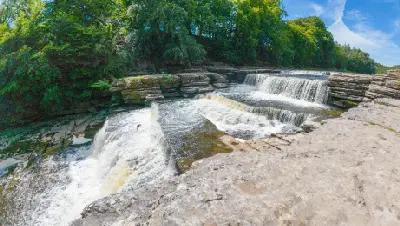 Elevated view of stepped waterfalls and exposed limestone terraces at Aysgarth Falls on the River Ure in the Yorkshire Dales, England.