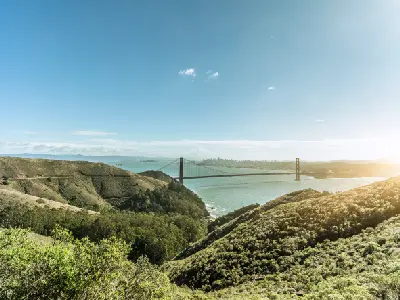 Golden Gate Bridge viewed from Hawk Hill across the Marin Headlands with San Francisco skyline in the distance, California