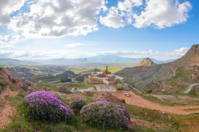 İshak Pasha Palace viewed across purple wildflowers and rugged mountains near Doğubayazıt, Eastern Turkey.