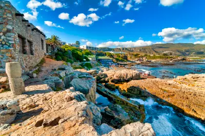 Historic stone buildings and rugged tidal shoreline at Old Harbour Hermanus along the Whale Coast in the Western Cape, South Africa
