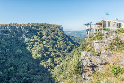 Graskop Gorge Lift visitor centre perched on the edge of a forested gorge, with adventure activities including a zipline and Big Swing visible in Mpumalanga, South Africa.