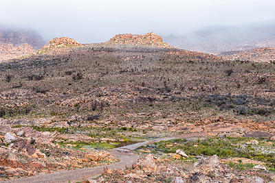 Remote gravel road crossing a shallow causeway in the rocky mountain landscapes between Matjiesrivier and Wupperthal in the northern Cederberg.