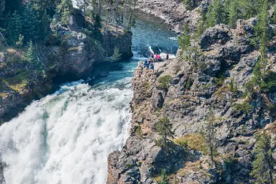 People standing at the brink viewpoint of the Upper Falls overlooking the Yellowstone River