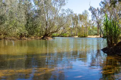 Clear waters of the Drysdale River flow between eucalyptus-lined banks and pandanus in the Kimberley.