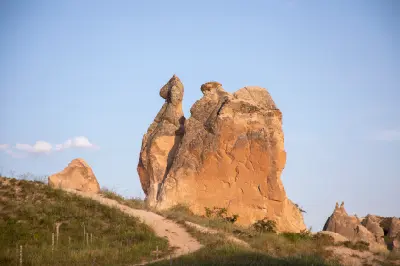 The naturally sculpted Camel Rock formation rising above the volcanic landscape of Devrent Valley (Imagination Valley) in Cappadocia, Turkey, illuminated by warm evening light.