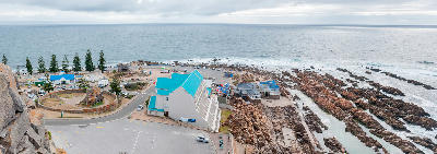 View over The Point in Mossel Bay with rocky shoreline, tidal pools and oceanfront buildings along the Garden Route coast.