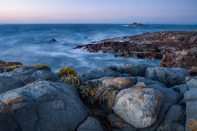 Rocky coastline and Scarp Island at Pearl Bay near Yzerfontein photographed at dusk with long-exposure Atlantic surf.