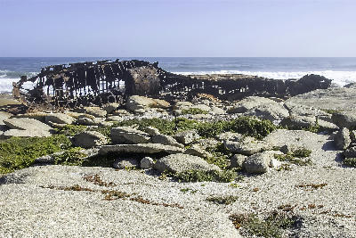 Rusted wreck of the Aristea ship on a rocky Atlantic coastline at Hondeklip Bay, Namaqualand, South Africa.