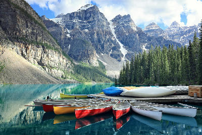 Canoes on Moraine Lake with turquoise water and mountain peaks in Banff National Park, Alberta, Canada