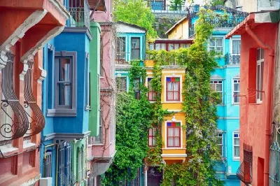 Brightly painted historic houses with bay windows and climbing greenery in Balat, Istanbul.