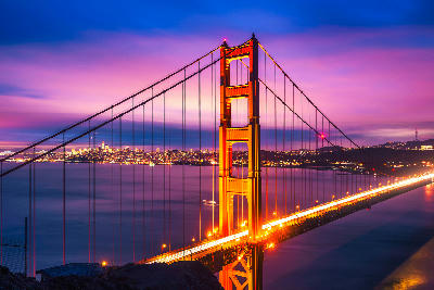 Golden Gate Bridge illuminated at night from Battery Spencer with San Francisco skyline beyond