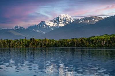 Mount Edith Cavell with snow-covered summit reflected in calm lake in Jasper National Park