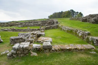 Ground-level view of ancient Roman stone foundations and grassy pathways at Housesteads Roman Fort in Northumberland.