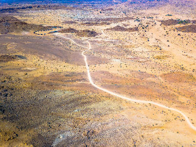 Aerial view of a gravel road cutting through desert terrain near Fish River Canyon in Namibia.