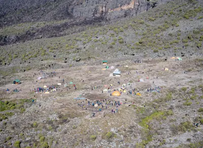 Barranco Camp viewed from the Barranco Wall on Mount Kilimanjaro, Tanzania, showing tents and alpine vegetation at approximately 3,950 metres above sea level.
