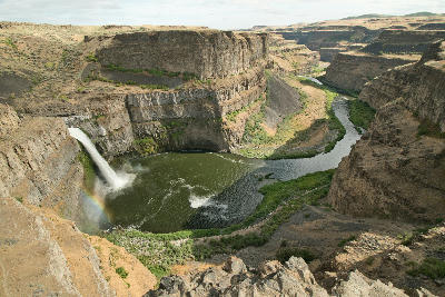 Palouse Falls plunging into a circular canyon basin with the river winding through basalt cliffs in Washington State