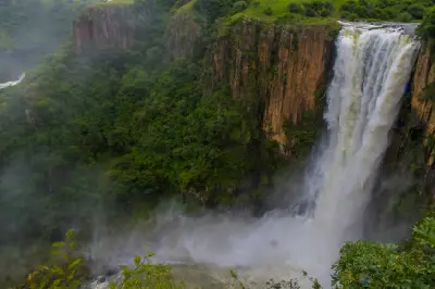 Howick Falls plunging over a sheer cliff into a misty forested gorge on the Umgeni River in the KwaZulu-Natal Midlands, South Africa.