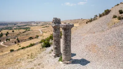 Surviving stone columns beside the burial mound at Karakuş Tumulus overlooking the dry landscape of Adıyaman, Turkey.