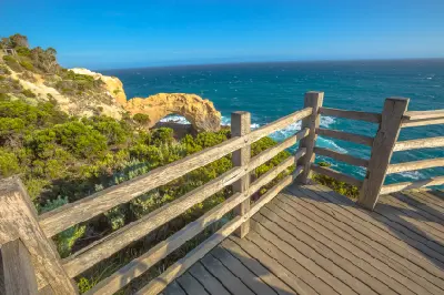 Wooden viewing platform overlooking The Arch and Southern Ocean in Port Campbell National Park, Victoria.