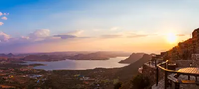 Golden sunset over Hartbeespoort Dam viewed from the summit of the Hartbeespoort Aerial Cableway, with mountain ridges, lakeshore settlements and viewing terraces in the foreground.