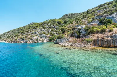 Clear turquoise Mediterranean water along the rocky, undeveloped coast of Kekova Island in Antalya, Turkey.