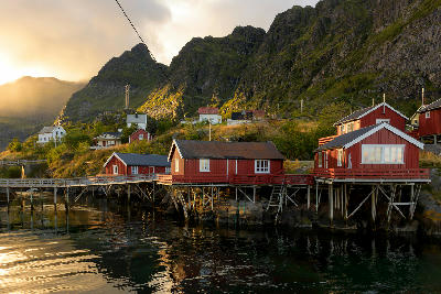 Red rorbuer cabins on stilts in Å on Moskenesøya at sunset, Lofoten Islands, Norway.