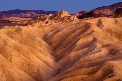 Zabriskie Point at twilight in Death Valley National Park California showing smooth eroded ridges and layered desert landscape