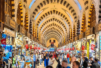 Interior of Istanbul’s Grand Bazaar with vaulted arches, shops and crowds of visitors.