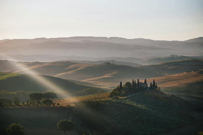 Podere Belvedere Villa in Val d'Orcia Region in Tuscany, Italy at Sunrise or Dawn, with a Light Ray in the Romantic Early Morning Light