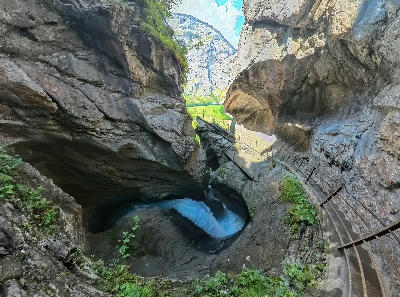 Trümmelbach Falls inside a narrow rock gorge with walkways and rushing glacial water in Lauterbrunnen Valley, Switzerland.