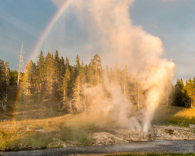Riverside Geyser eruption rainbow twilight Yellowstone