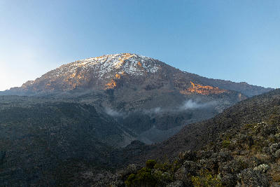 Snow-covered upper slopes of Kibo below Uhuru Peak on Mount Kilimanjaro at sunrise, Tanzania.
