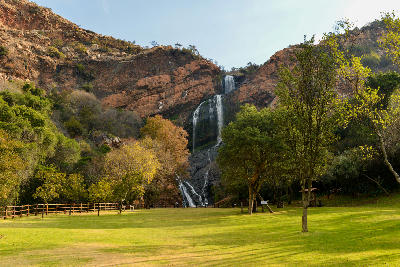 Witpoortjie Waterfall cascading down quartzite cliffs in Walter Sisulu National Botanical Garden, surrounded by indigenous trees and open lawns in Roodepoort.