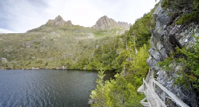 Timber boardwalk on the Dove Lake Circuit beside the lake and beneath Cradle Mountain in Tasmania, Australia.