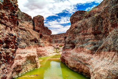 Rock walls and green water pools inside Sesriem Canyon near Sossusvlei in Namibia.