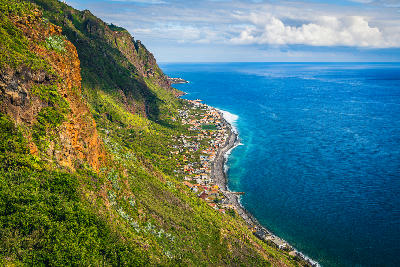 Clifftop view from the Massapez Viewpoint overlooking Paul do Mar on Madeira’s west coast, with steep green cliffs dropping to the Atlantic Ocean.