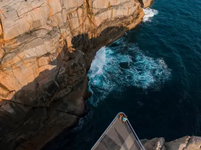 Aerial view of visitors on The Gap lookout above ocean waves and granite cliffs in Torndirrup National Park, Western Australia.