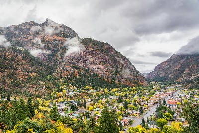 Autumn view over Ouray with golden aspens and dramatic cliffs along the Million Dollar Highway, Colorado, USA.