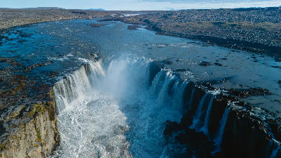 Selfoss waterfall in North Iceland, showing a broad curtain of water flowing over a rocky cliff into the canyon along the Jökulsá á Fjöllum River.