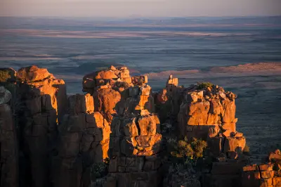 Sunlit sandstone pinnacles of the Valley of Desolation overlooking the vast Great Karoo near Graaff-Reinet, Eastern Cape, South Africa.