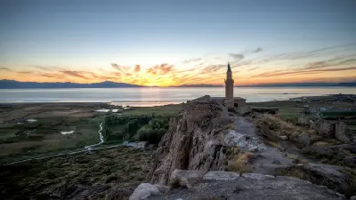 Sunset over Lake Van viewed from Van Castle, with the Süleyman Han Mosque minaret standing on the rocky citadel in eastern Turkey.