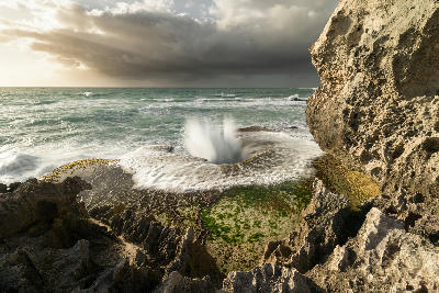 Waves exploding through eroded limestone rock formations near Arniston and Waenhuiskrans on South Africa’s Southern Cape coast.