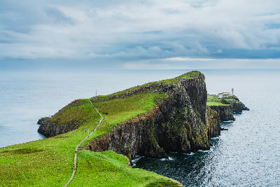 Neist Point Lighthouse and nearby cottages on the western edge of the Isle of Skye, set above steep cliffs and open sea.