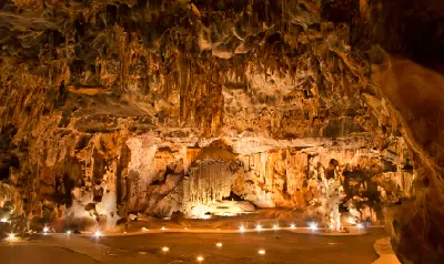 Wide view of illuminated stalactites and limestone cave formations inside the Throne Room chamber of the Cango Caves near Oudtshoorn in South Africa.